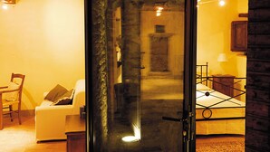 A room with a bed, a chair, a small table, and a lamp. - Relais La Torre (Arezzo)