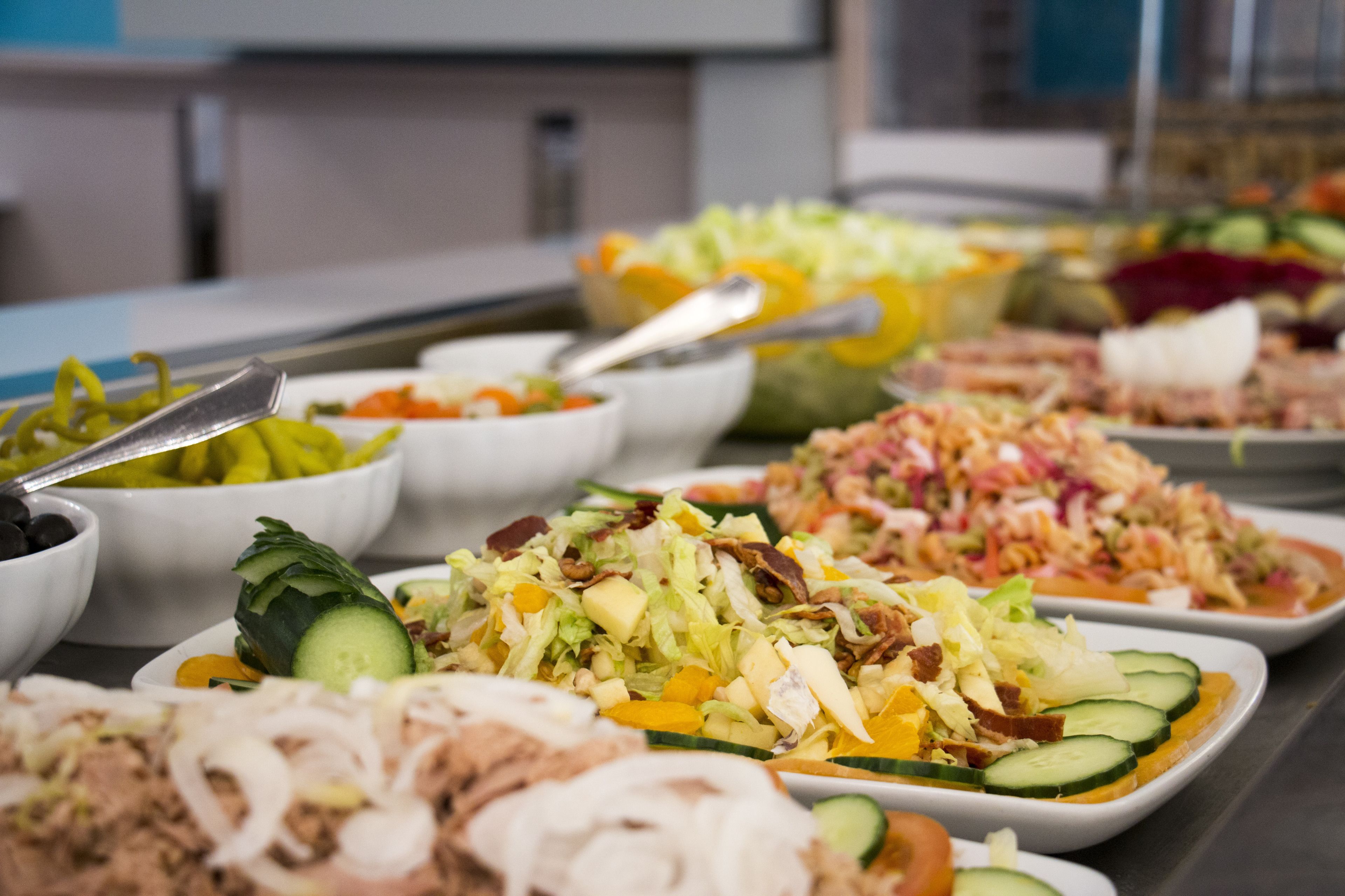 A buffet table with various dishes including salads, meats, and vegetables.