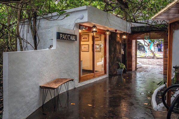 Un edificio con un letrero que dice "PACCARI" y una banca de madera afuera.
