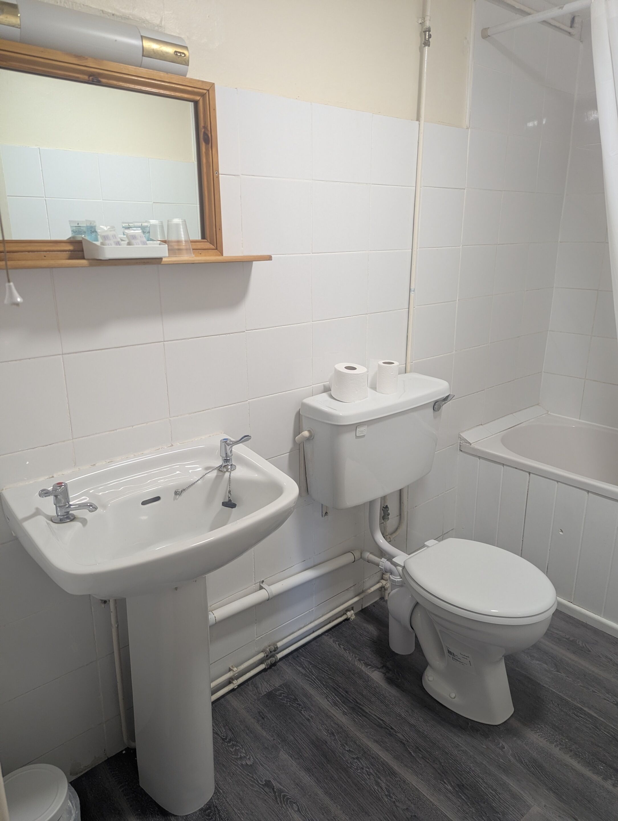 A bathroom with a sink, toilet, and shower.