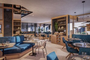 A modern restaurant interior with seating arrangements, a bar area, and a view of the cityscape. - INNSiDE by Meliá Palma Avenidas (Palma de Mallorca)