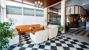 A lobby with a checkered floor, a sofa, armchairs, a chandelier, and a glass partition. - Hotel THB Felip - Adults Only (Manacor)