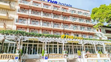 A multi-story hotel with balconies, a cafe, and a restaurant on the ground floor.