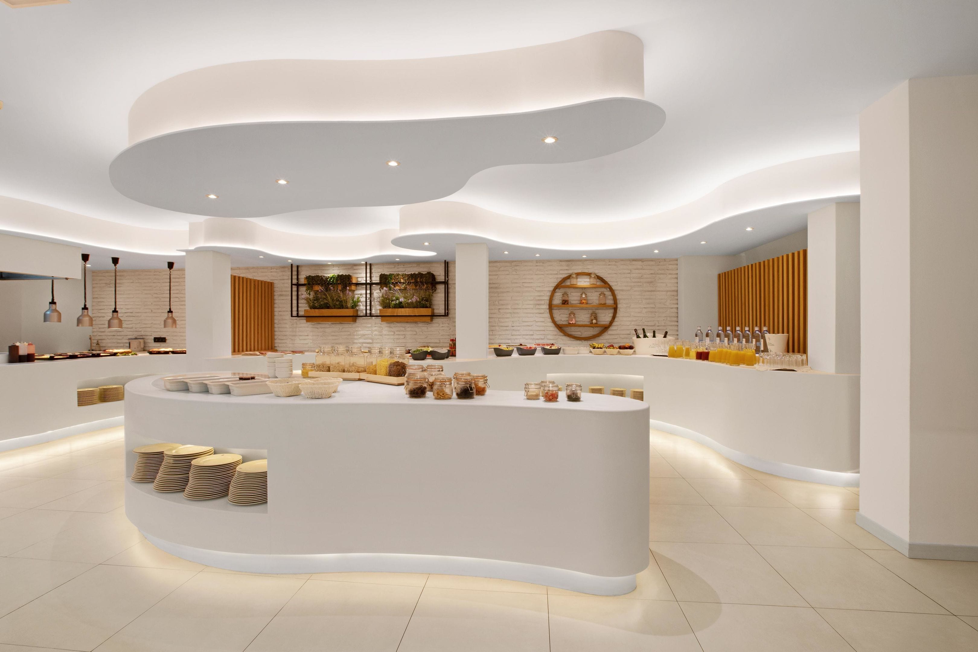 A modern, well-lit kitchen area with a central island, various kitchen appliances, and neatly arranged utensils.