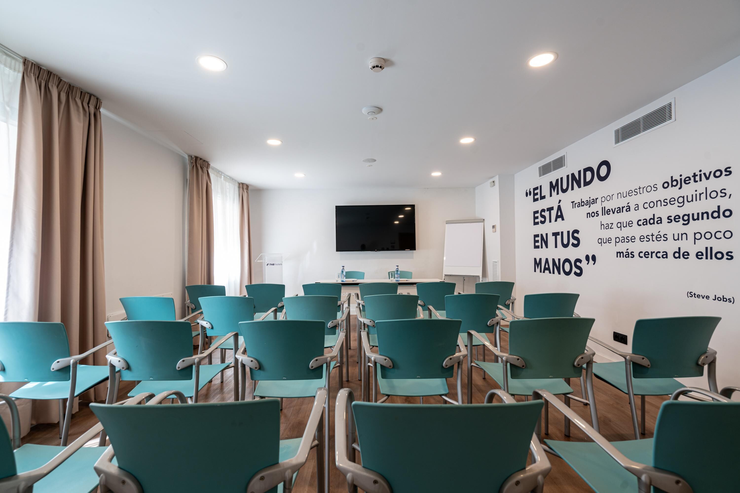 A conference room with teal chairs and a whiteboard.