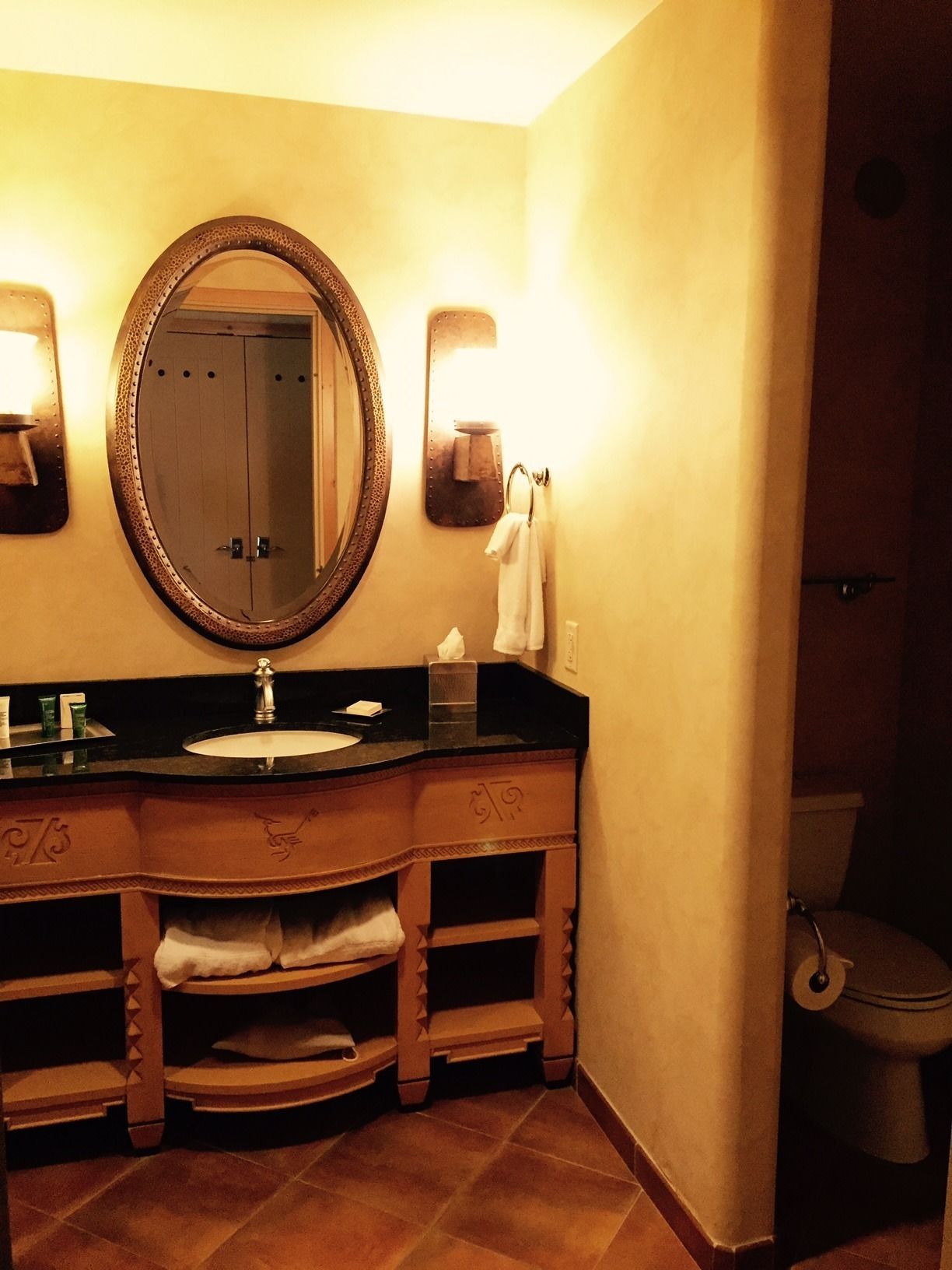 Un baño con un espejo grande, un lavabo y un inodoro.