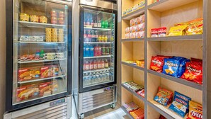 Två kylskåpsdiskar fyllda med olika sorters matvaror och en hylla med påsar med snacks.