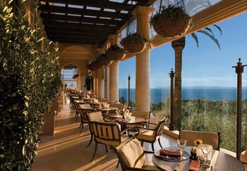 Enjoy meals in a spacious dining area with high ceilings and expansive views of the surrounding landscape. at The Resort at Pelican Hill