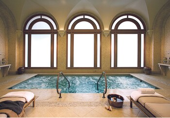 Relax by the pool surrounded by classic architecture and comfortable lounge chairs. at The Resort at Pelican Hill