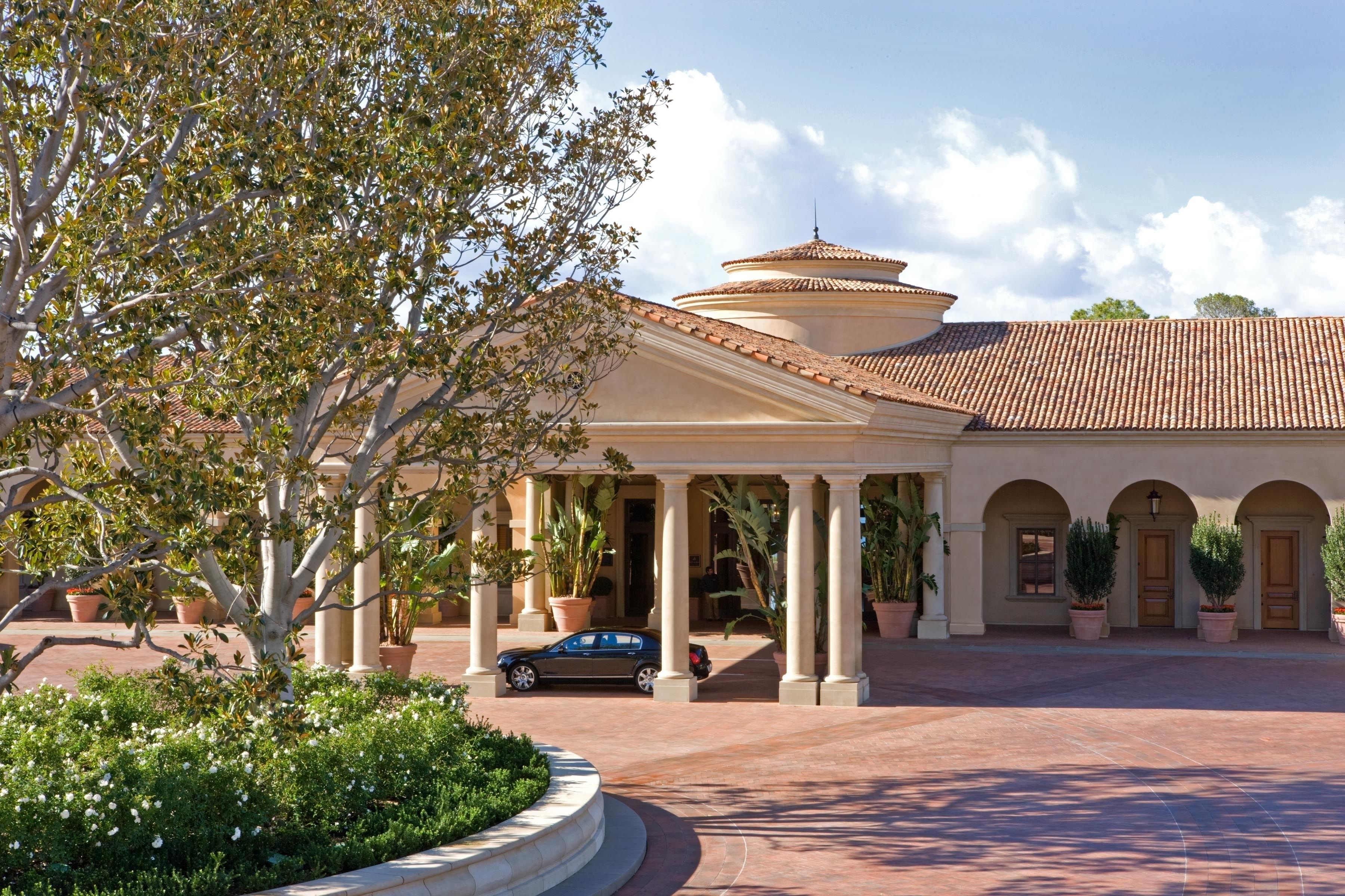 A building with a circular central courtyard, columns, and a tiled roof.