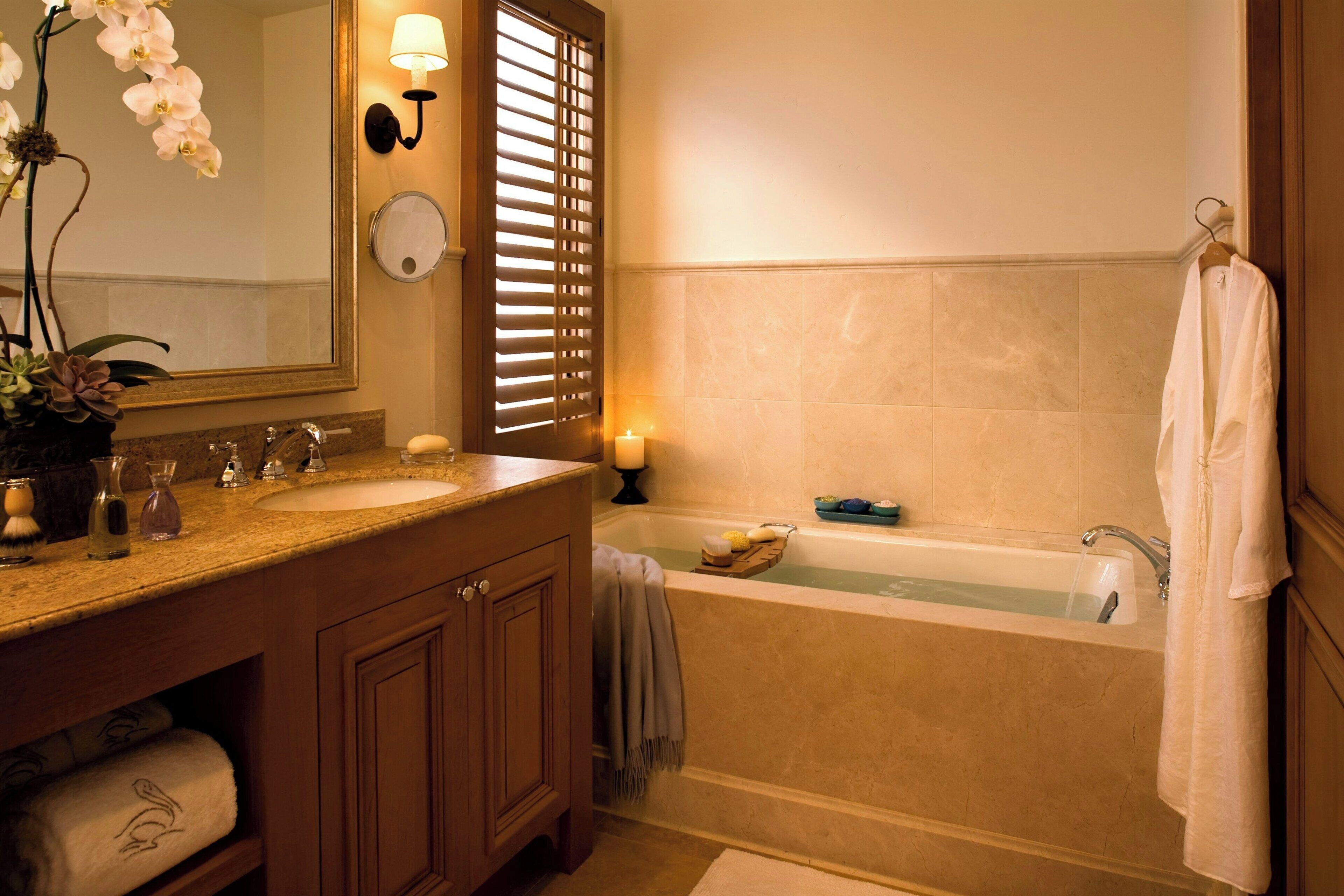 A bathroom with a sink, mirror, and bathtub.