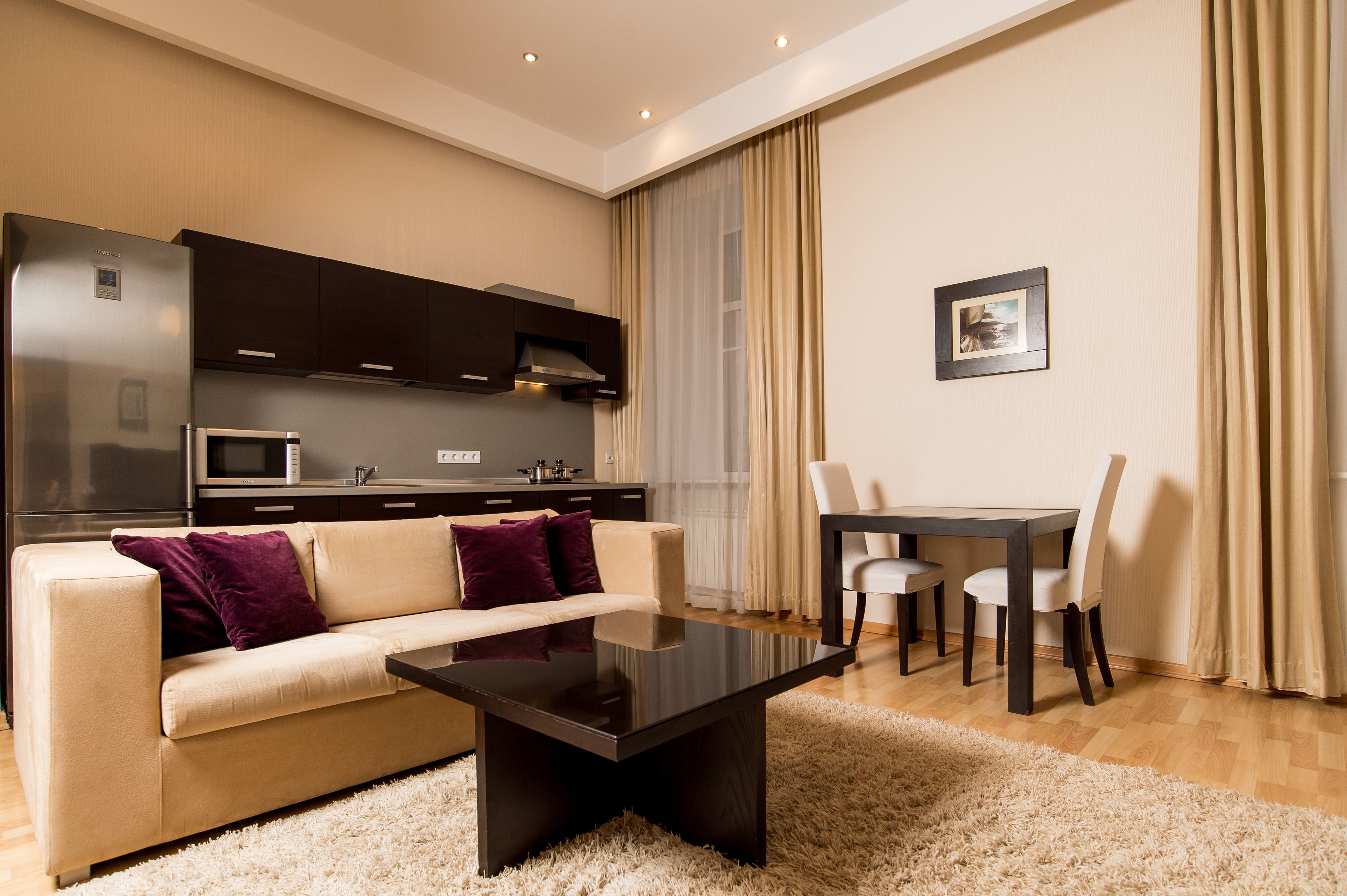 Een moderne woonkamer met een bank, een salontafel, en een eethoek met stoelen en een tafel.