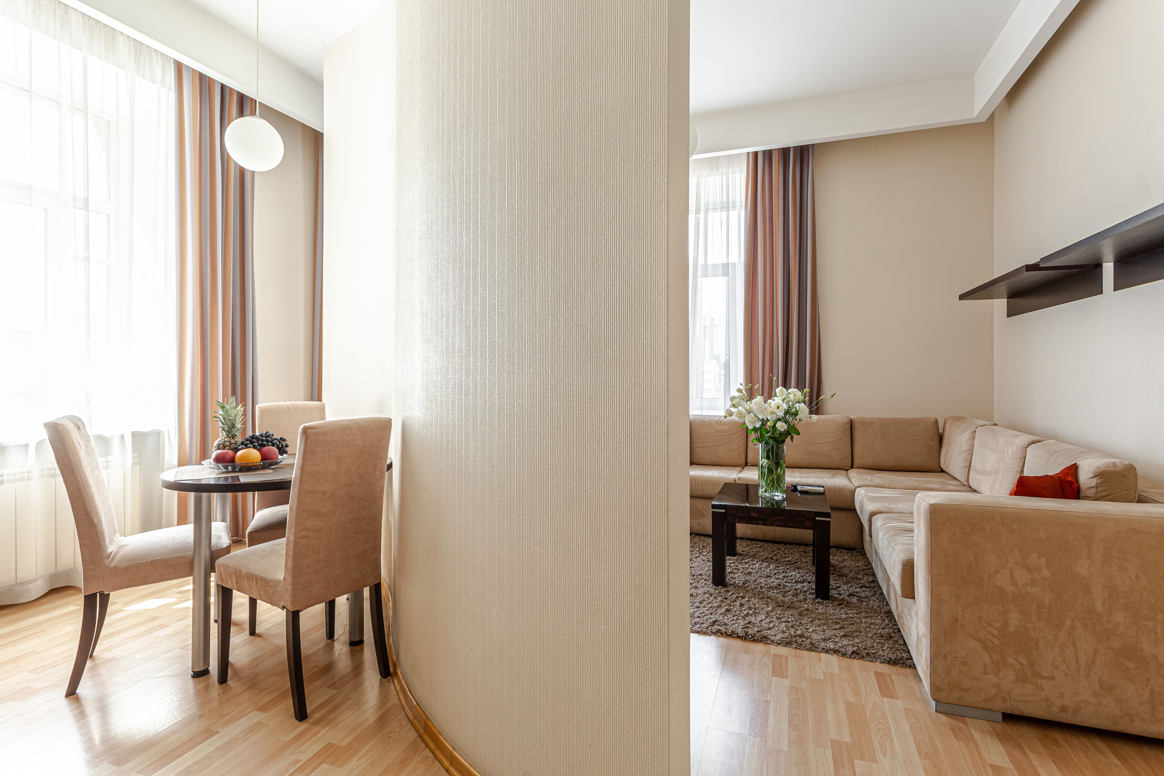 Una sala moderna con un sofá, una mesa de comedor con sillas y una mesita de centro.
