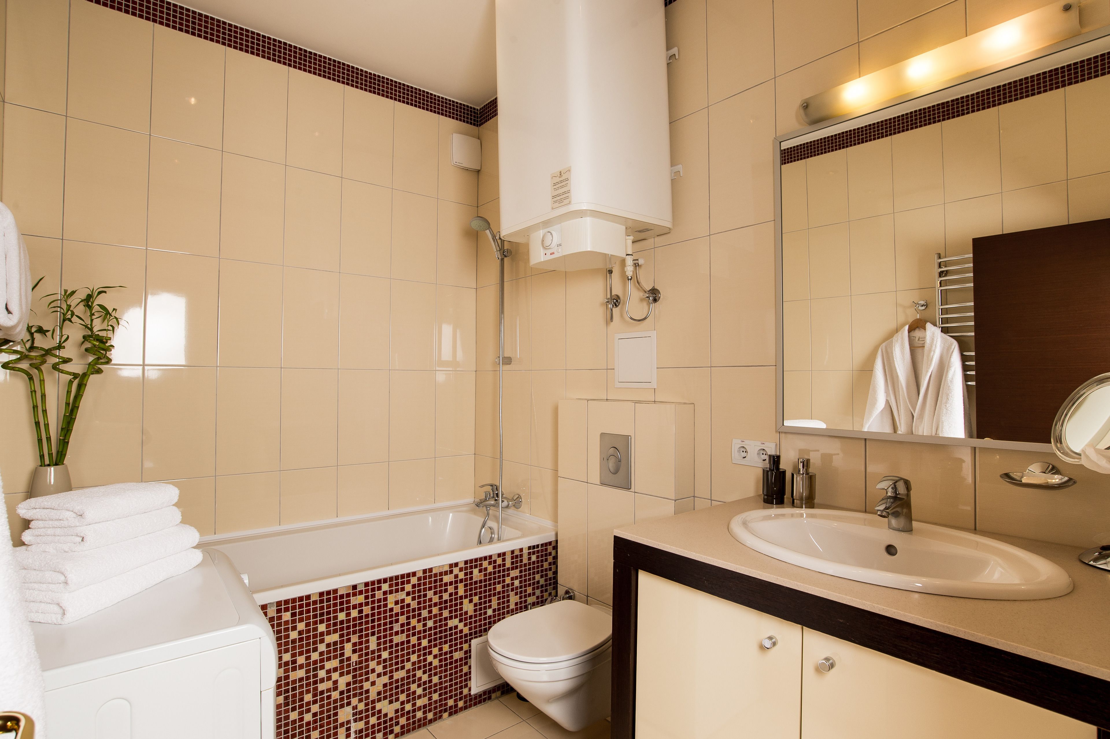 A bathroom with a bathtub, toilet, sink, and a mirror.