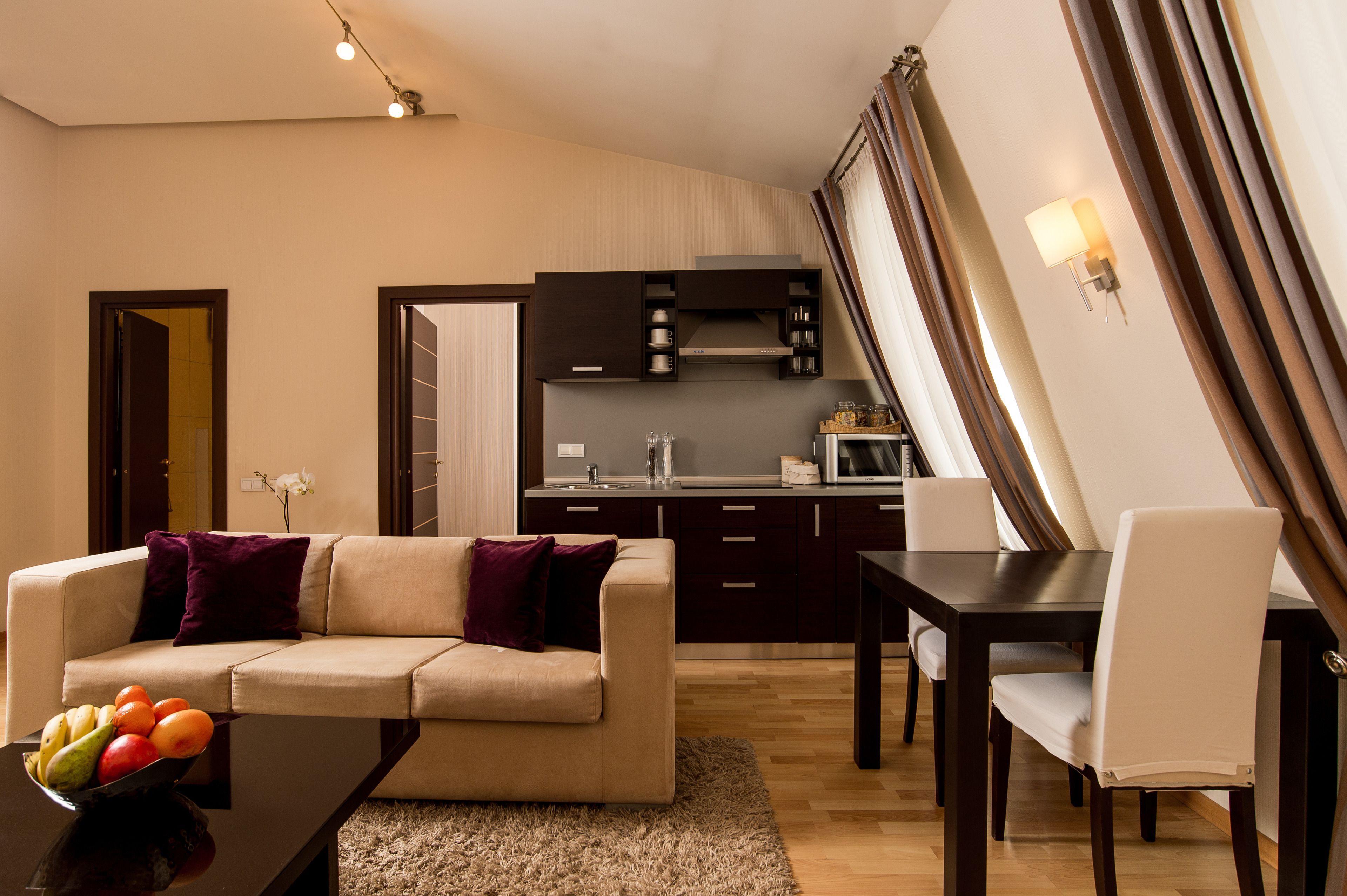 Un salon moderne avec un canapé, une table à manger et une cuisine en arrière-plan.