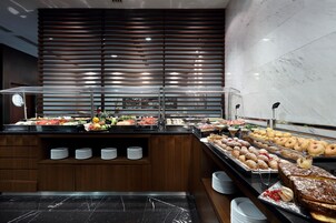 A buffet with various food items and a wooden slatted wall in the background.