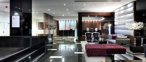 A modern lobby with a checkered floor, seating areas, and a reception desk.
