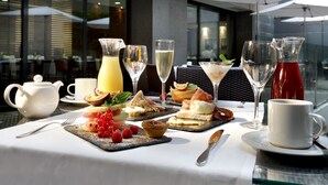 Una mesa con una variedad de alimentos, bebidas y utensilios para el desayuno.