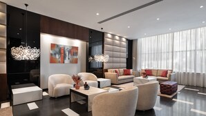 Una sala moderna con sofá, sillones y una mesa de centro.