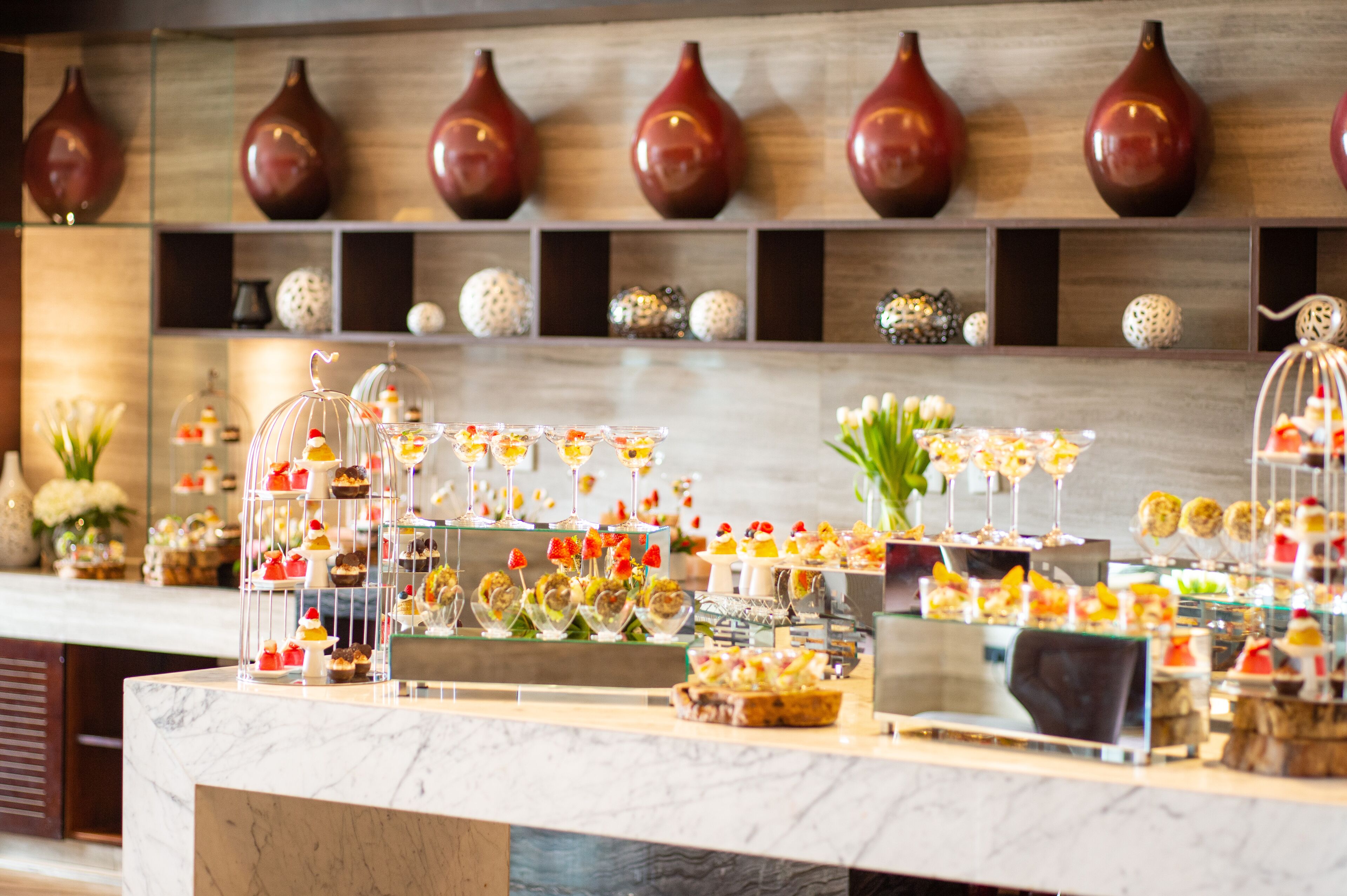 A buffet with various food items displayed on glass stands.
