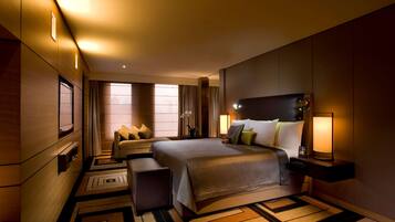 Quarto de hotel com uma cama grande, mesas de cabeceira e uma janela com cortinas.