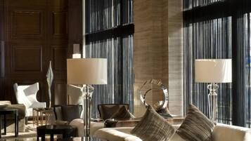 A spacious, elegantly furnished lounge area with a large sofa, armchairs, and a coffee table.