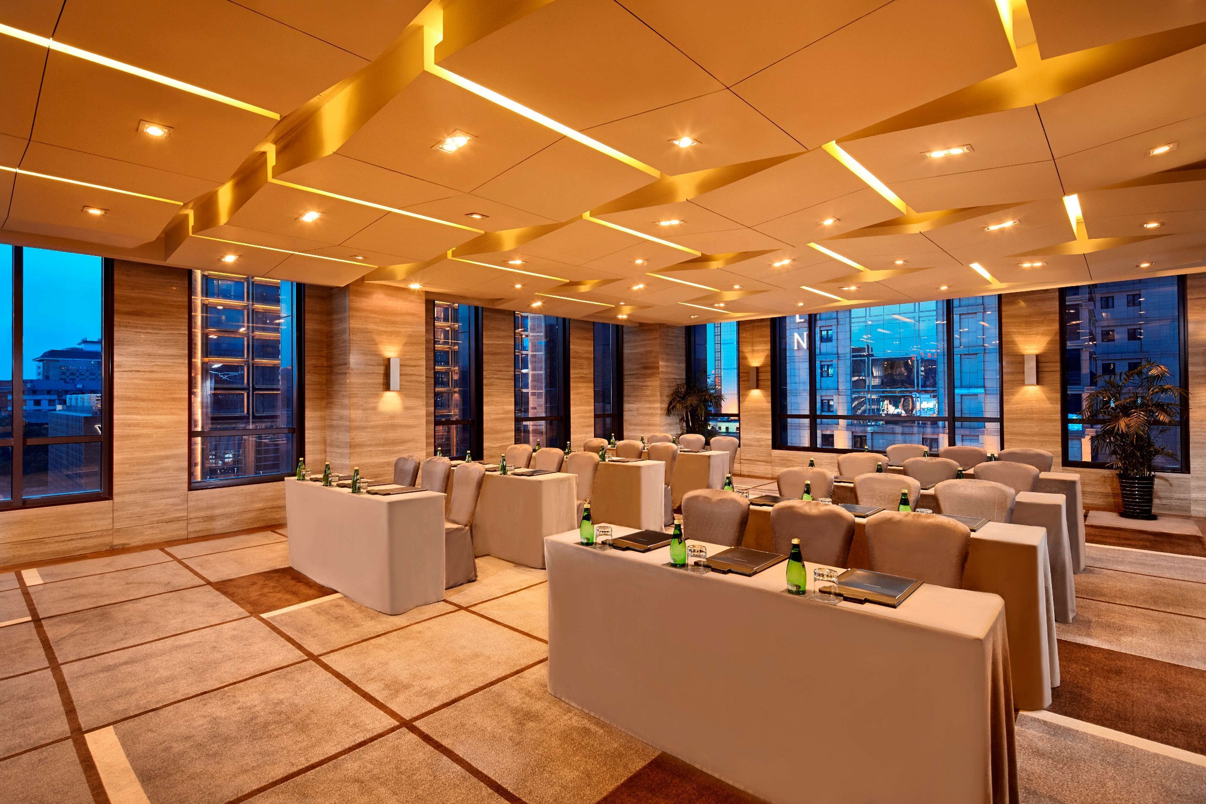 A modern conference room with multiple seating areas, large windows, and a clean, contemporary design.