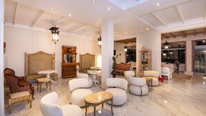 A spacious lobby with a high ceiling, marble flooring, and a variety of seating options including armchairs and sofas. - Orpheas Resort - Adults Only (Apokoronas)