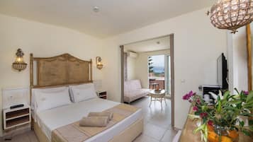Una camera d'albergo con un letto grande, un comodino, una lampada, una televisione e vista all'esterno.