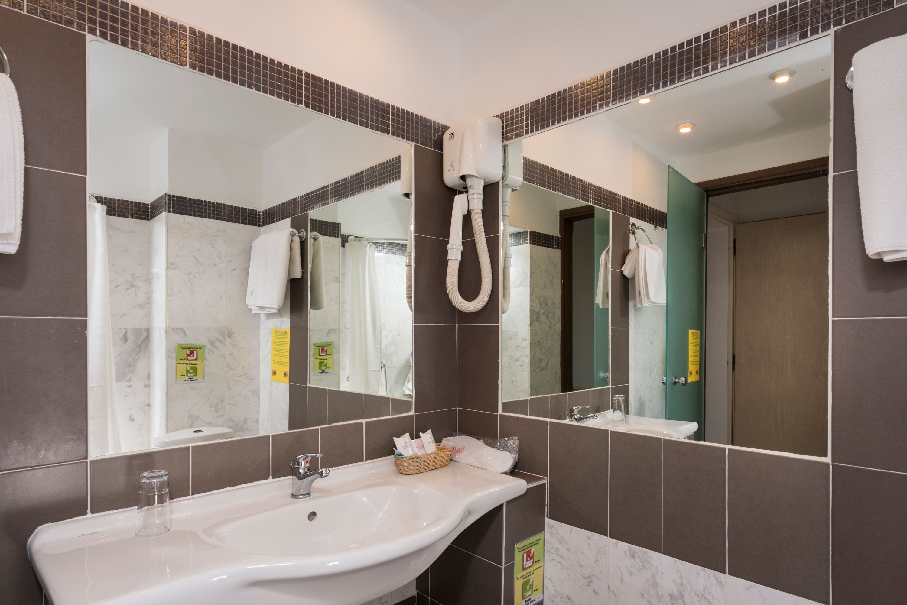 A bathroom with a large sink, a mirror, and a towel rack.