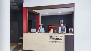 Uma receção com um letreiro que diz "BEM-VINDOS A AVIGNON" e um design de interiores moderno.