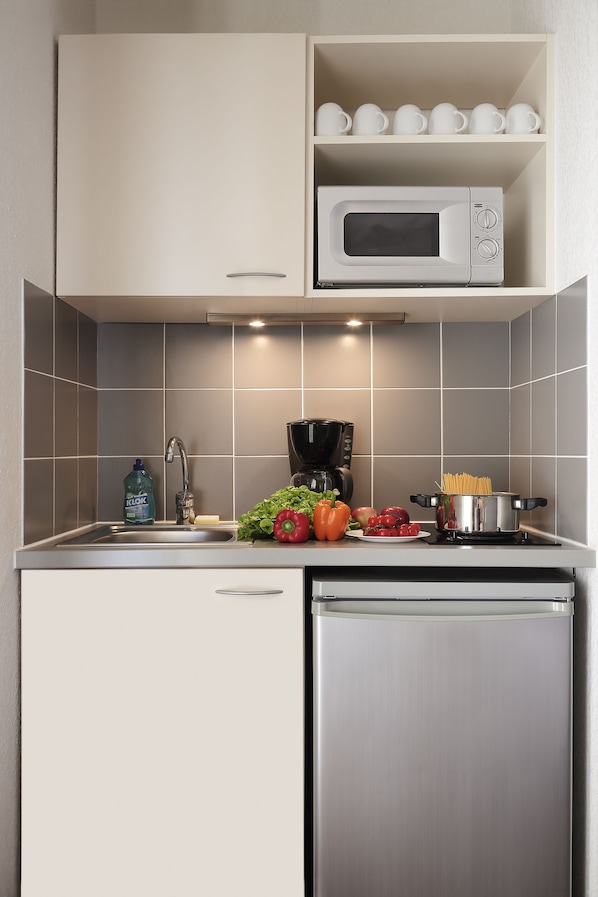 A kitchen with a microwave, sink, and a coffee maker.