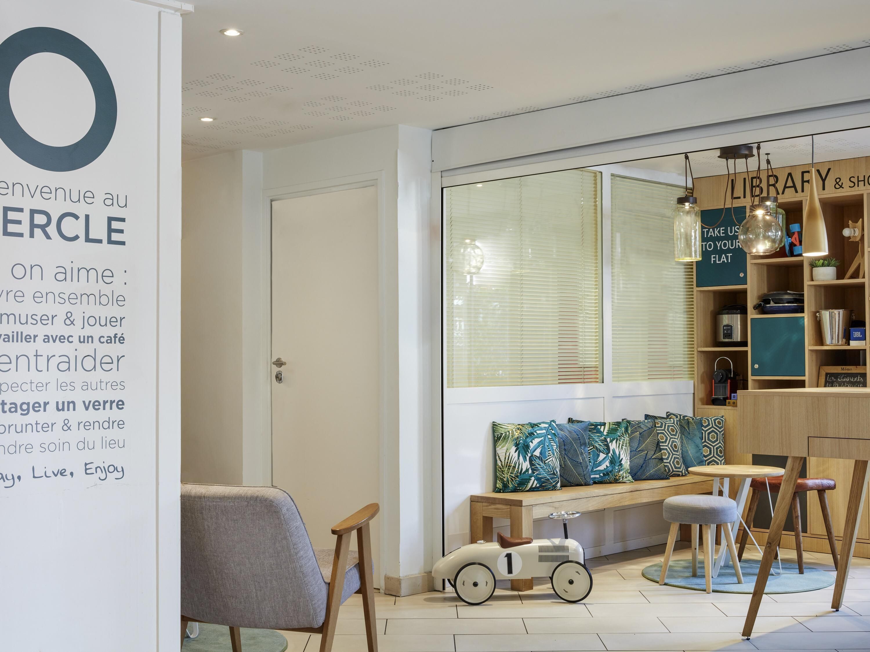 A modern interior with a seating area, a bookshelf, and a sign with text.