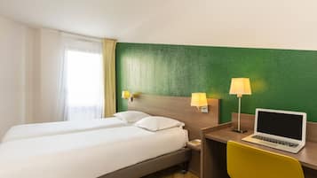 Habitación de hotel con dos camas, un escritorio con una computadora portátil y dos lámparas de pared.