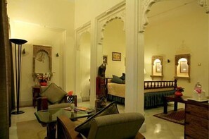 A traditional living room with a sofa, a coffee table, and a dining area with a table and chairs.