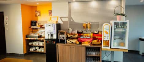 Een moderne keukenhoek met een koffieapparaat, een koelkast en diverse etenswaren op het aanrecht.