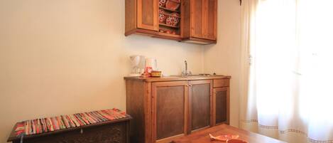 A kitchen with wooden cabinets, a countertop, and a sink.