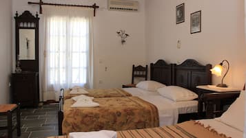 Un dormitorio con dos camas, un aparador, una silla y una mesita de noche con lámpara.