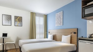 A hotel room with two beds, a desk, a chair, a TV, and artwork on the walls. - Aparthotel Adagio Access Paris Quai D'Ivry (Ivry-sur-Seine)