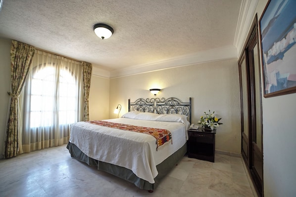Un dormitorio con una cama, una mesita de noche, una lámpara y un cuadro en la pared.