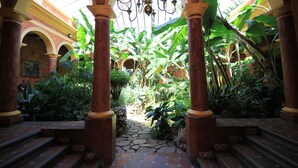 An indoor garden with stone steps, large columns, and a chandelier.