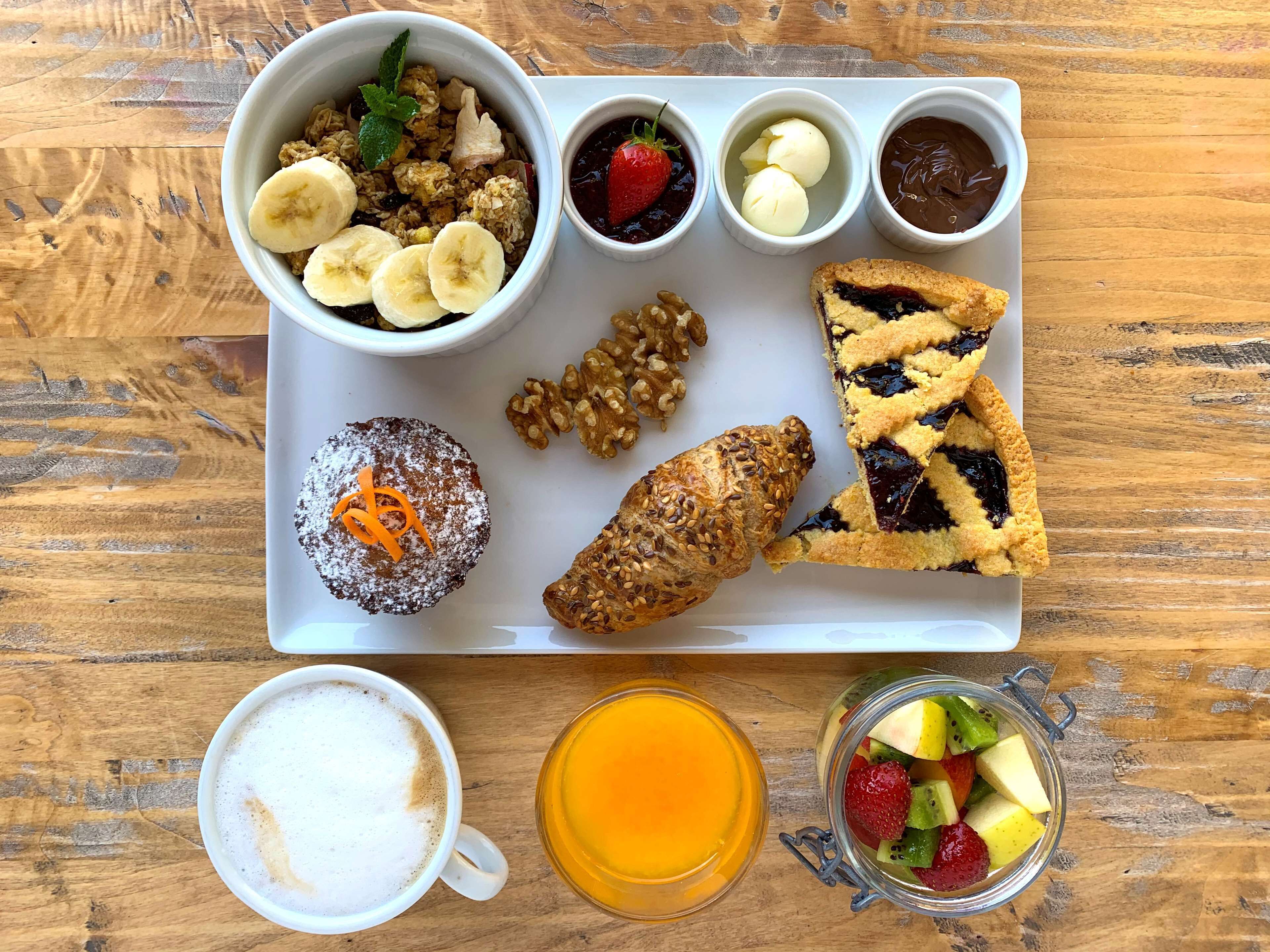 Una bandeja de desayuno con diversos alimentos y bebidas.
