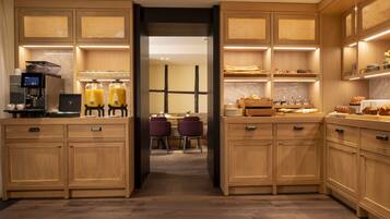 Una cocina moderna con armarios de madera, una cafetera y una barra para desayunar.