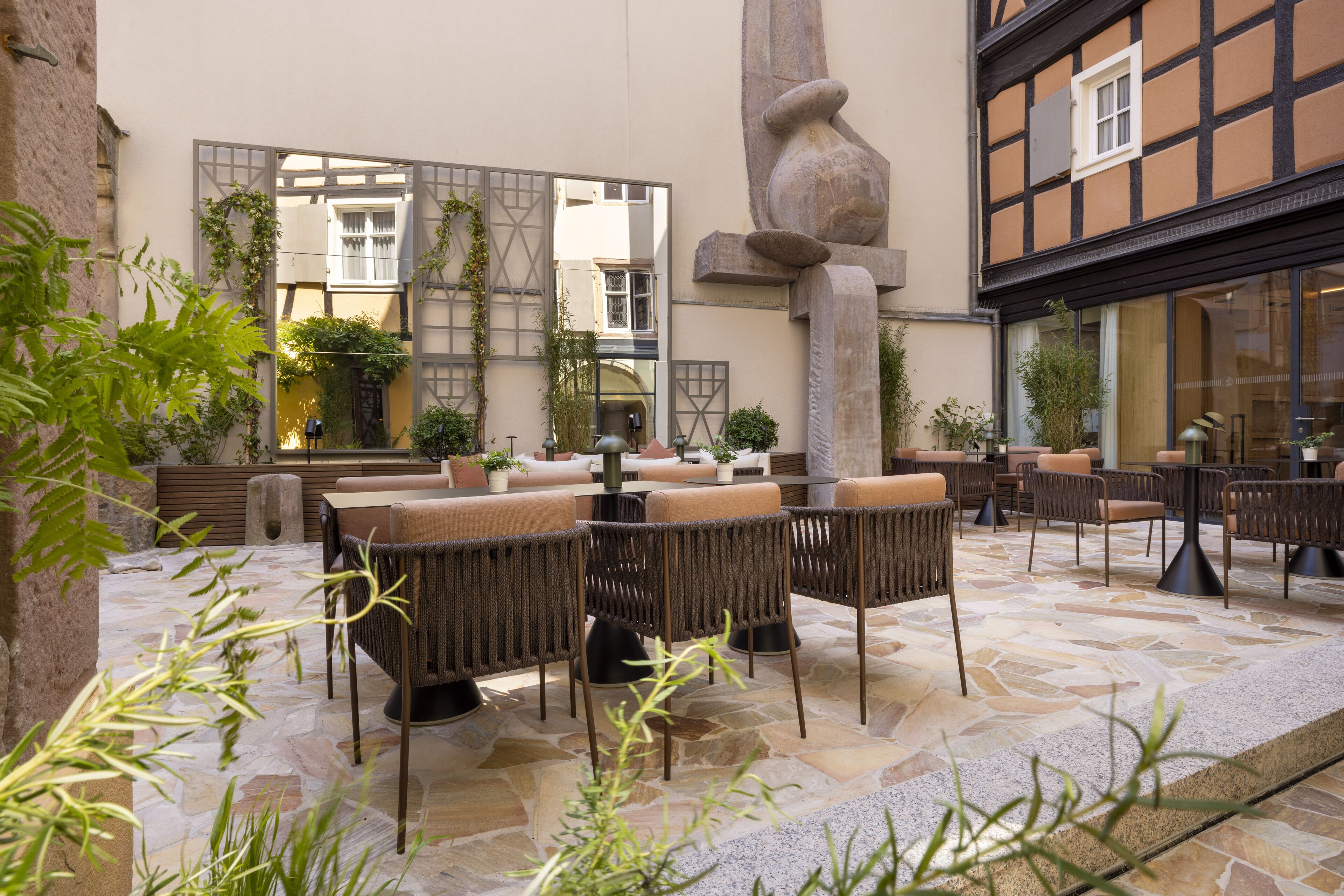 An outdoor seating area with stone flooring and wicker furniture.