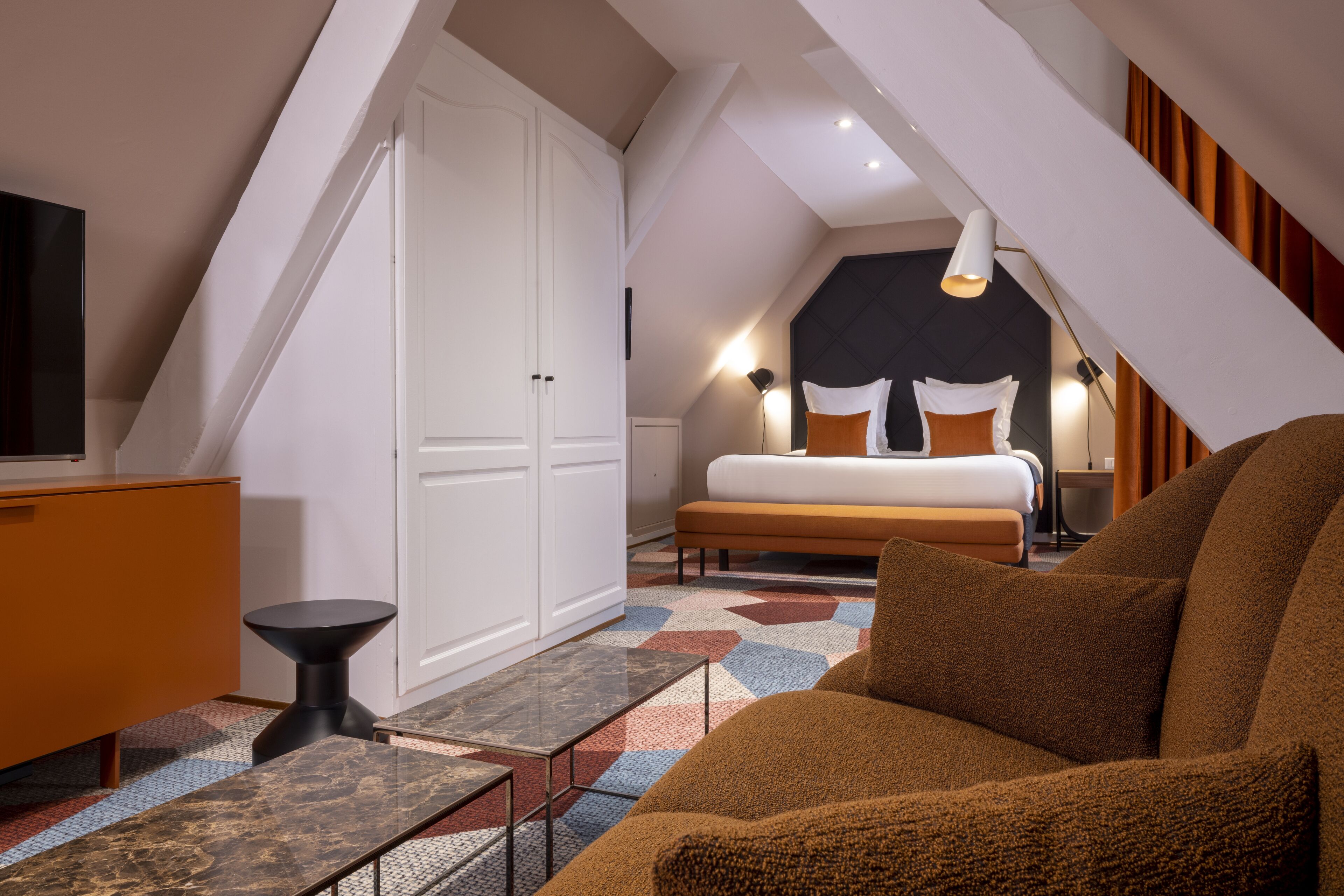 Une chambre moderne avec un grand lit, une télévision et un bureau.