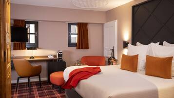 Une chambre d’hôtel avec un lit, un bureau, une chaise et un téléviseur.