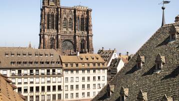 A cathedral with a tall spire, surrounded by historic buildings with traditional European architecture.