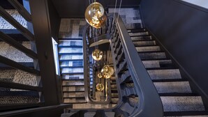 A modern staircase with a metal railing and a patterned wall. - Hôtel Gutenberg (Strasbourg)