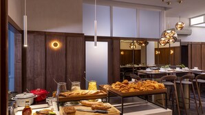 A breakfast buffet with various pastries and a bottle of liquor. - Hôtel Gutenberg (Strasbourg)