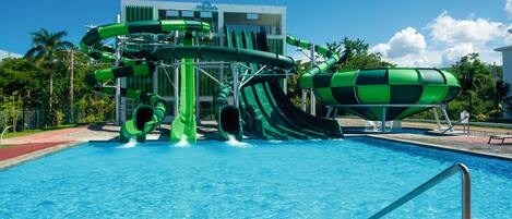 Parque acuático con múltiples toboganes y una piscina.